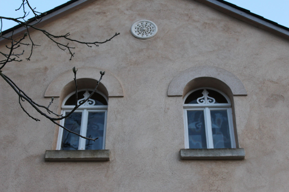 Detail Nordgiebel zur Straße mit neuer Lüftungsrosette und aufgearbeiteten Fenstern