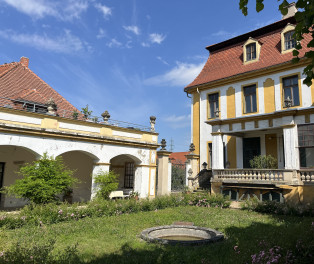 Blick auf den Gartenpavillon (links), Terrasse und Schloss mit überdachter Terrasse (rechts)