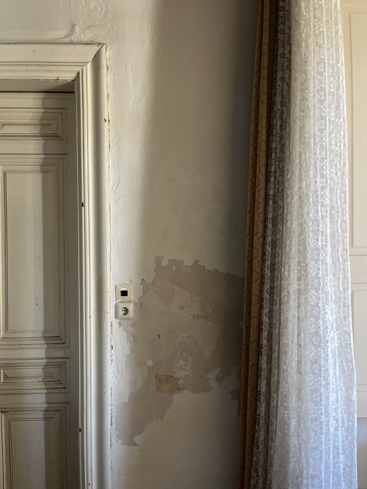 Innenraum Südseite, Detail Wand mit Steckdose und Türrahmen