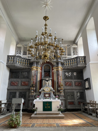 Blick in den Kirchenraum Richtung Osten, farbig marmorierter Kanzelaltar aus Holz mit geschwungenen Volutenkonsolen und Orgel auf einer geschwungenen Empore